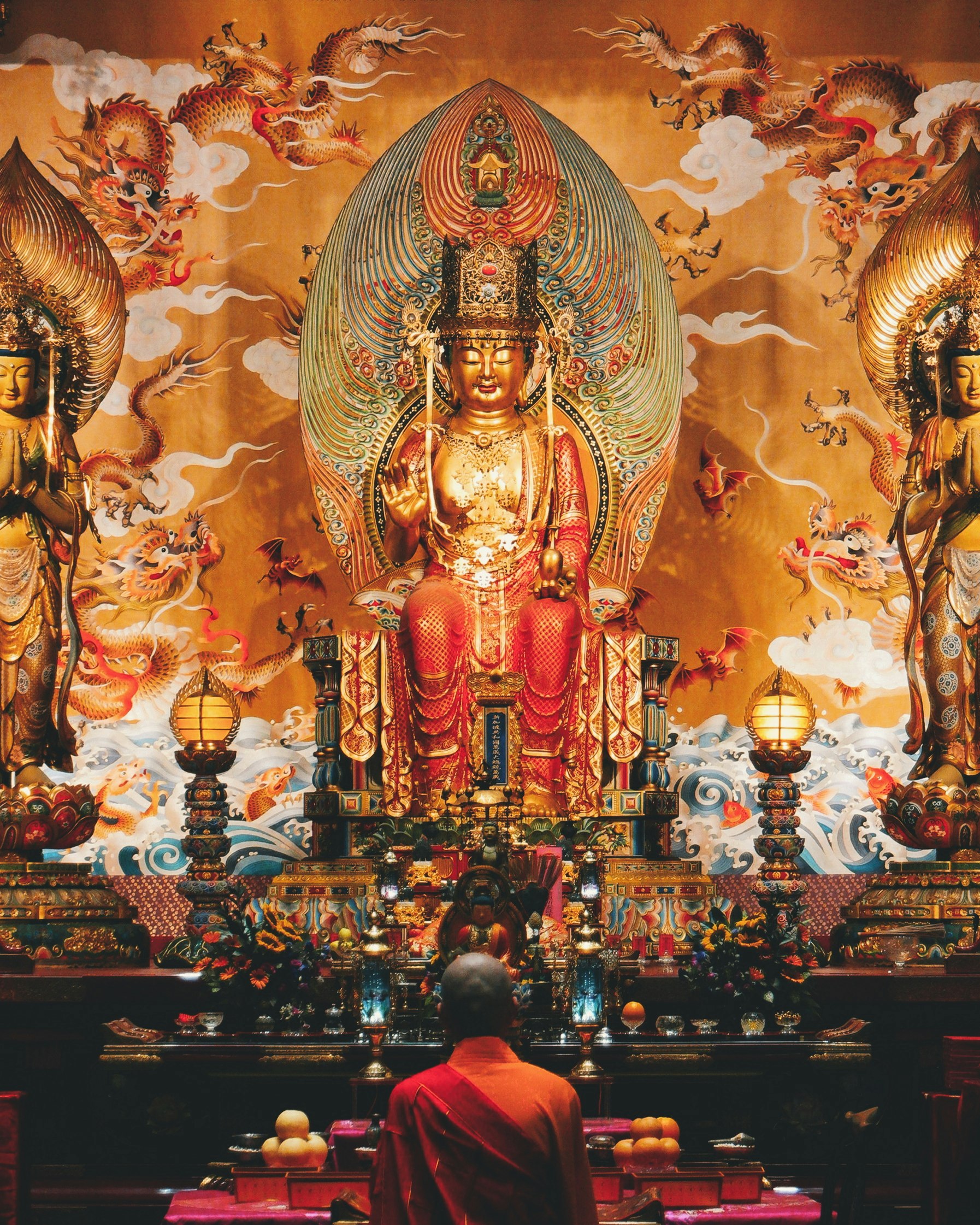 man wearing orange suit facing Hindu deity photography